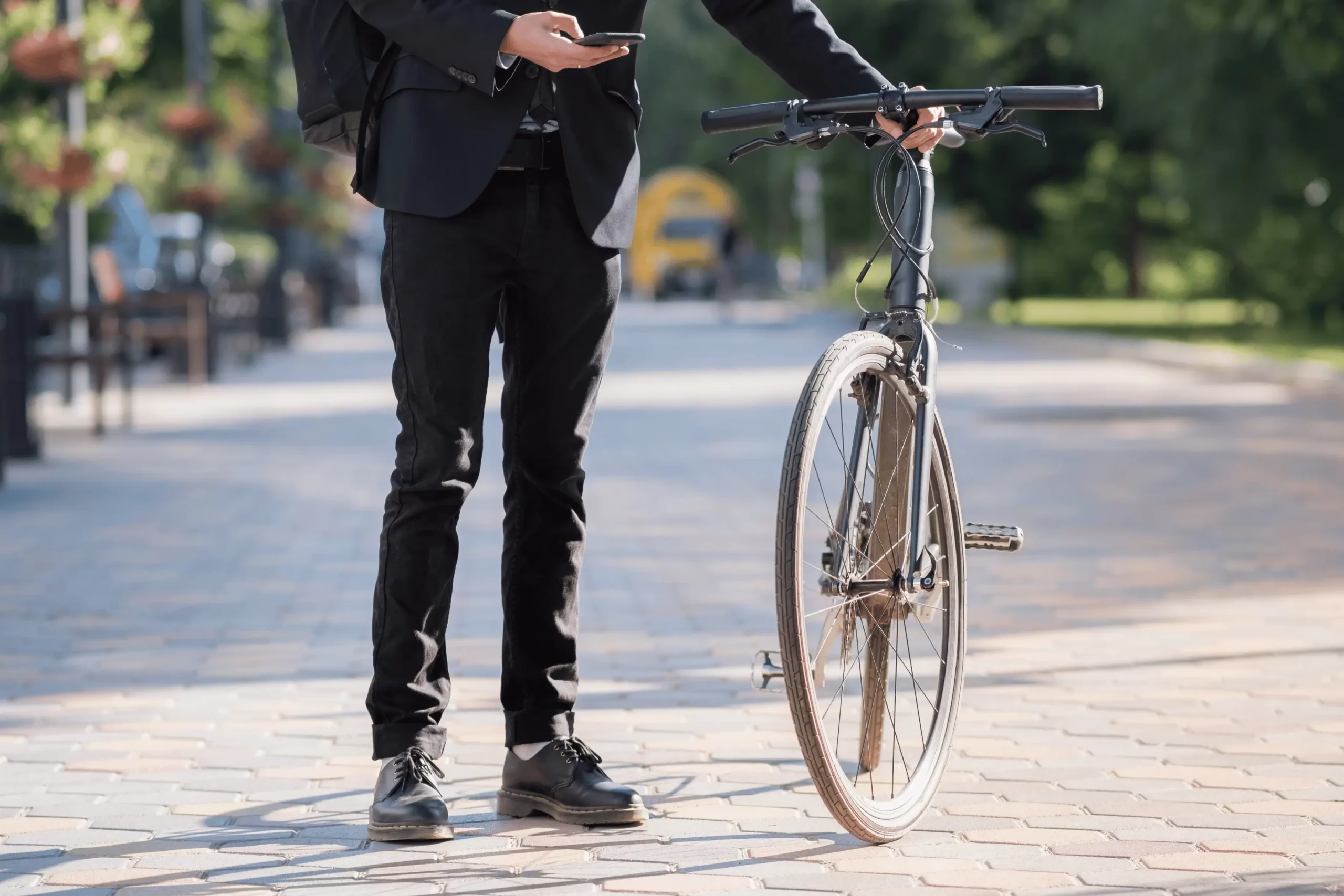 Mann im Anzug mit Fahrrad – Symbolbild für Nachhaltigkeit im Unternehmen