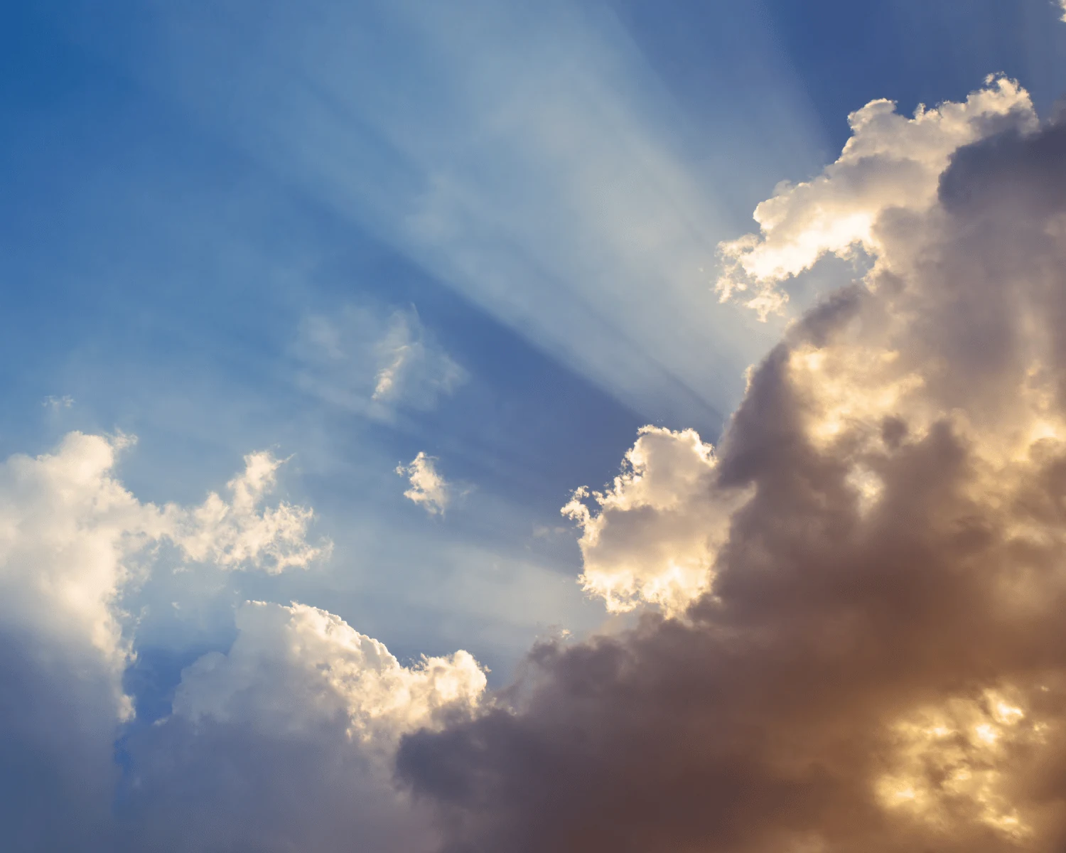 Sonnenstrahlen brechen durch Wolken hindurch – Symbolbild für die Chancen, die die CSRD bringt, auch wenn sie erst einmal wie belastende Bürokratie wirkt