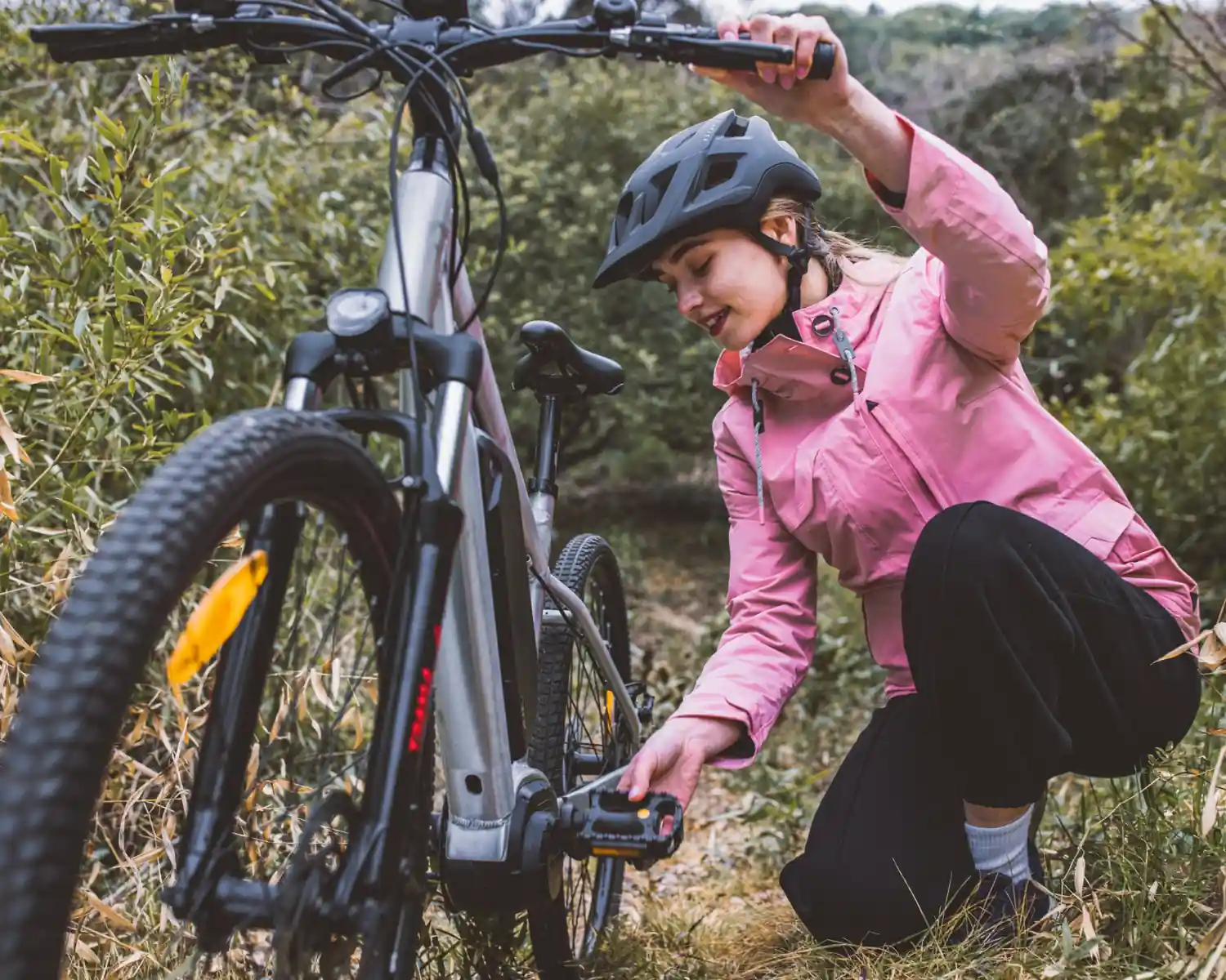 Radfahrerin prüft etwas an ihrem Fahrrad. Symbolbild ESG-Compliance in der Lieferkette der Fahrradbranche