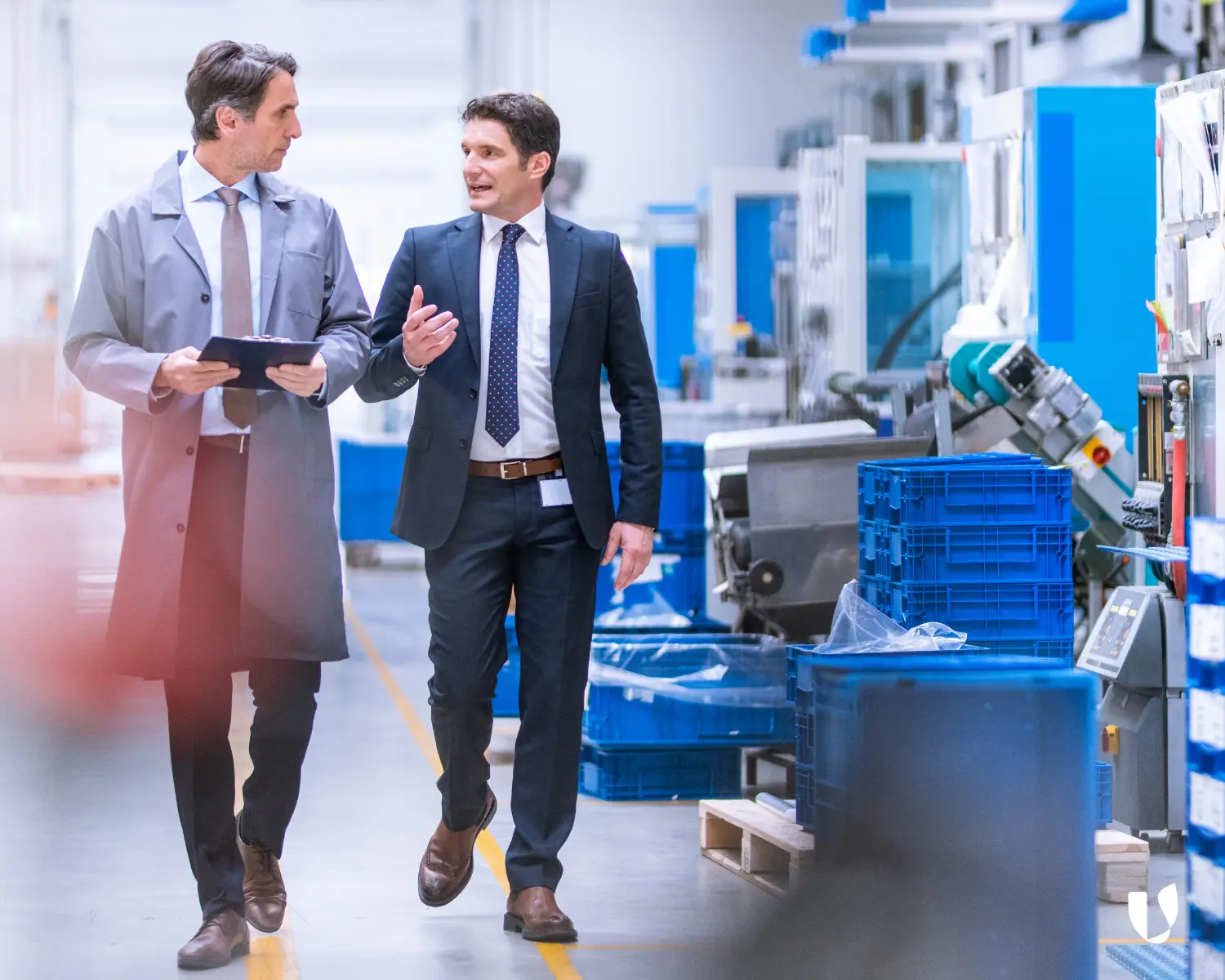 Supplier Management in der Lieferkette: Zwei Personen in einer Fabrikhalle als Symbol für nachhaltige Lieferantenbeziehungen und ESG-Compliance